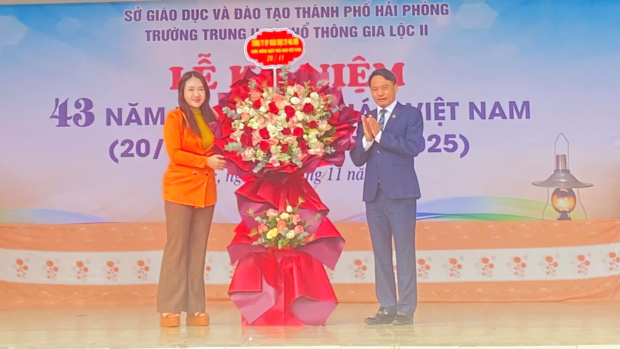 Đại diện Công ty Cổ phần Giáo dục 2T lên trao tặng lẵng hoa cho Hiệu trưởng nhà trường - Thầy Trương Hồng Phương.